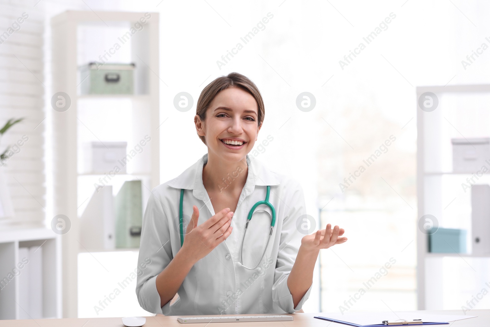 Photo of Female doctor using video chat at workplace, view from camera perspective