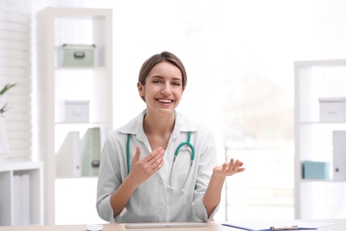 Female doctor using video chat at workplace, view from camera perspective