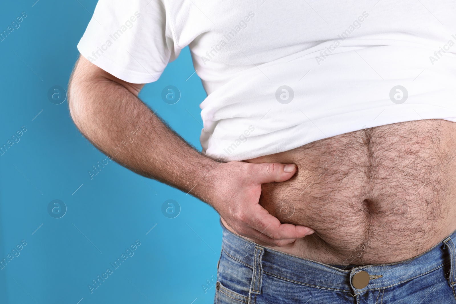 Photo of Overweight man with large belly on color background, closeup