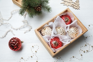 Composition with beautiful Christmas baubles on white wooden table, above view