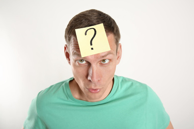 Photo of Emotional man with question mark on white background
