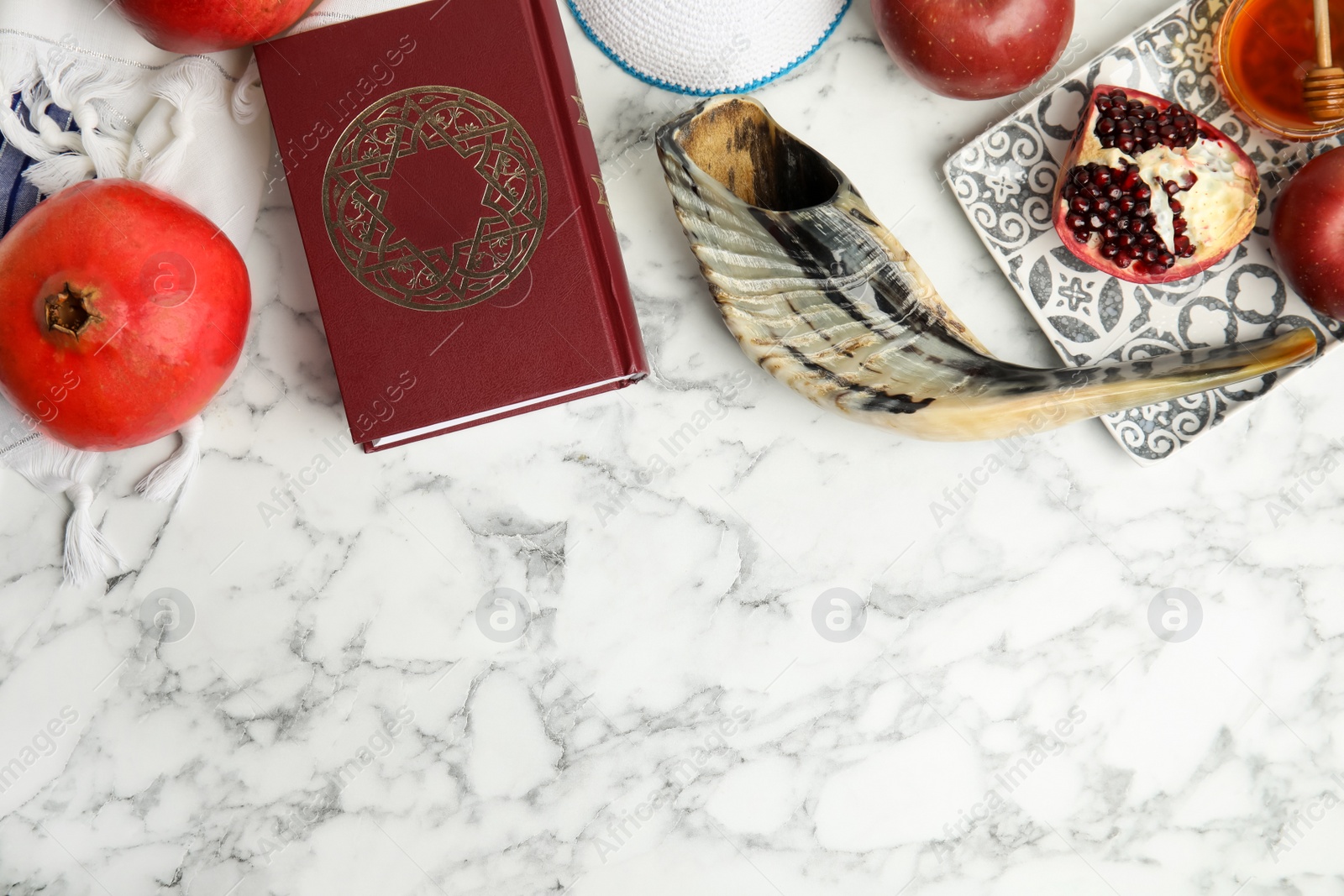 Photo of Flat lay composition with Rosh Hashanah holiday symbols on white marble table. Space for text