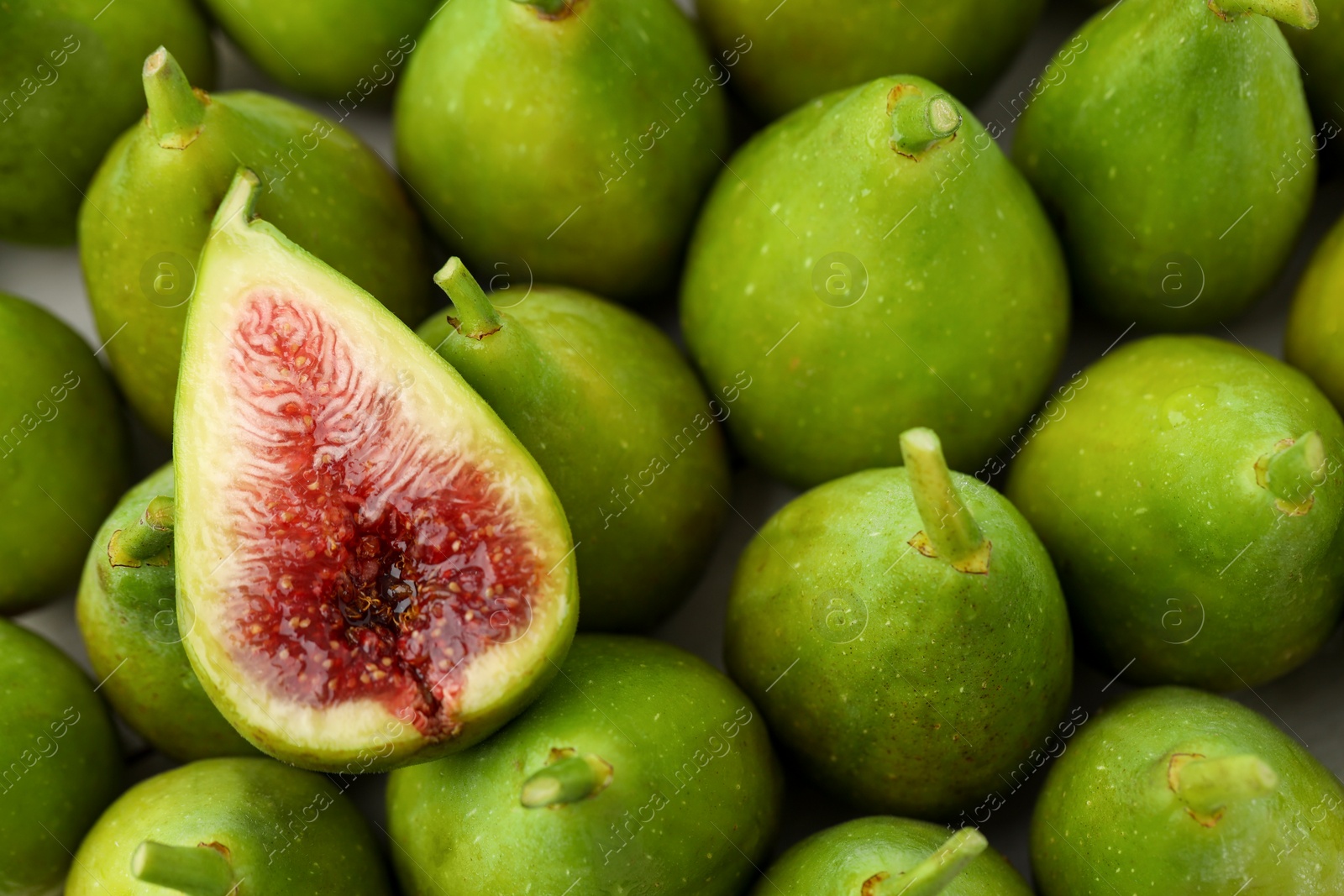 Photo of Cut and whole fresh green figs as background, top view