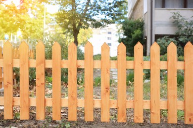 Wooden fence near building outdoors on sunny day