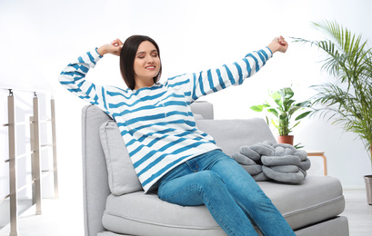 Photo of Young woman relaxing on couch at home