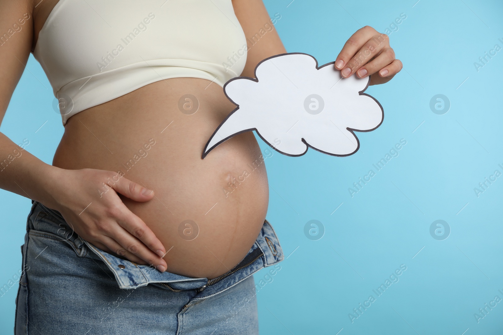 Photo of Pregnant woman with empty paper thought cloud on light blue background, closeup. Choosing baby name