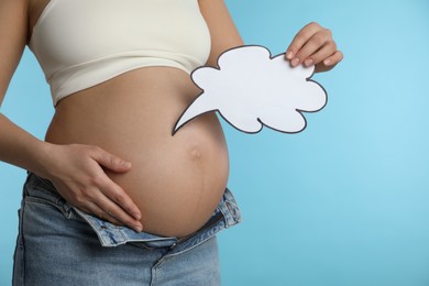 Photo of Pregnant woman with empty paper thought cloud on light blue background, closeup. Choosing baby name
