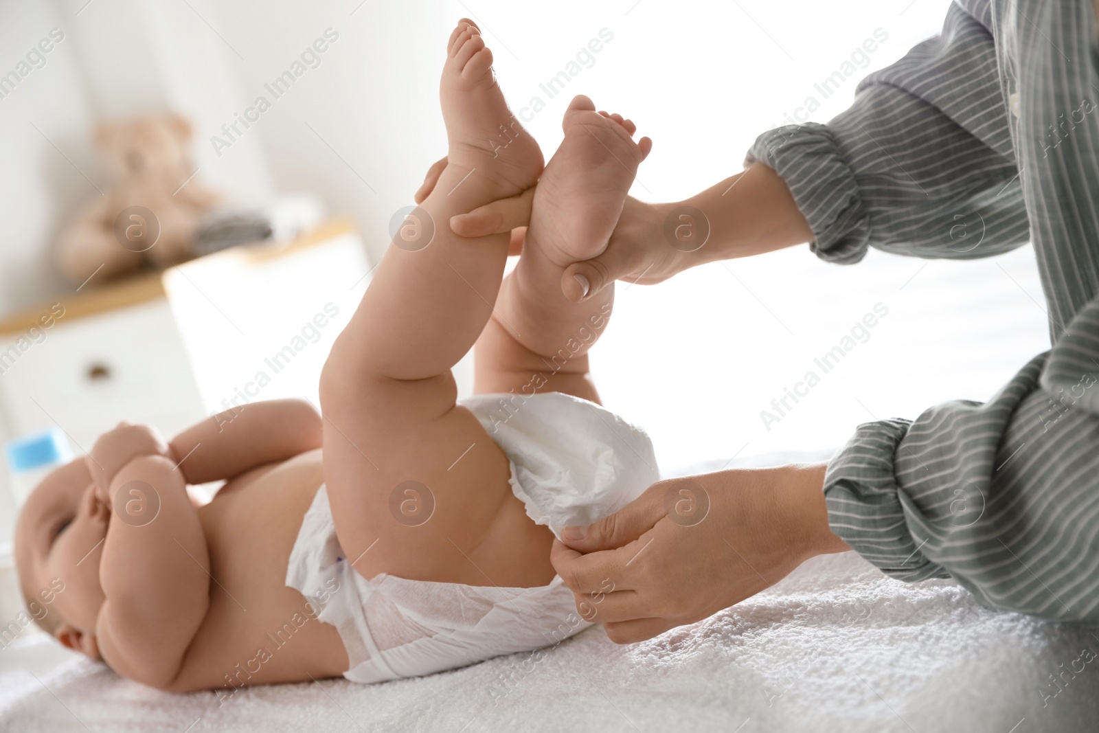 Photo of Mother changing her baby's diaper on table