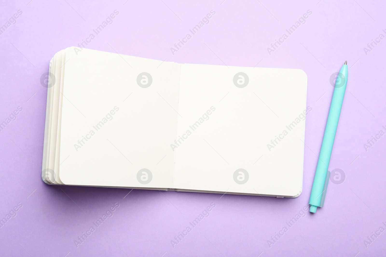 Photo of Stylish open notebook and pen on lilac background, flat lay