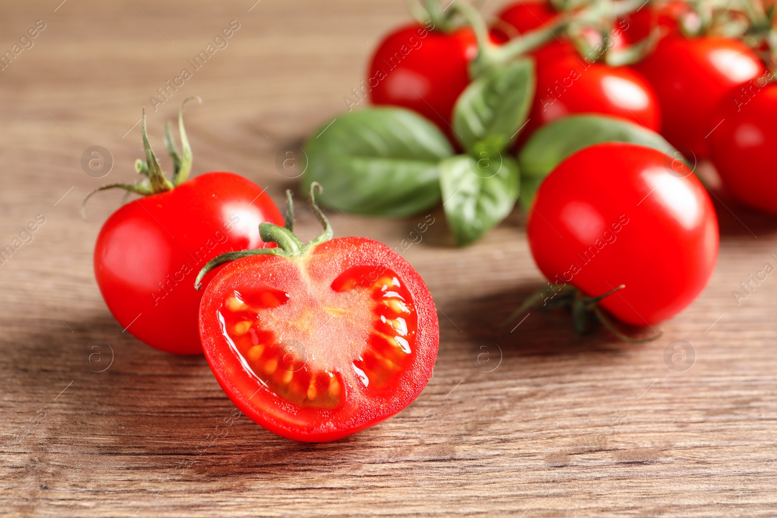 Photo of Fresh cherry tomatoes on wooden background, closeup