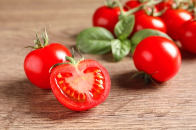 Photo of Fresh cherry tomatoes on wooden background, closeup