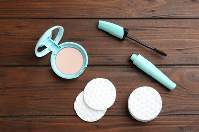 Photo of Flat lay composition with cotton pads, powder and mascara on wooden background