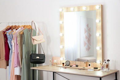 Photo of Stylish room with dressing table, mirror and wardrobe rack