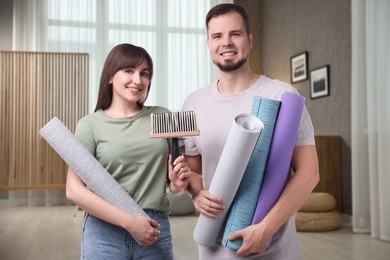 Image of Couple with wallpaper rolls and brush in room