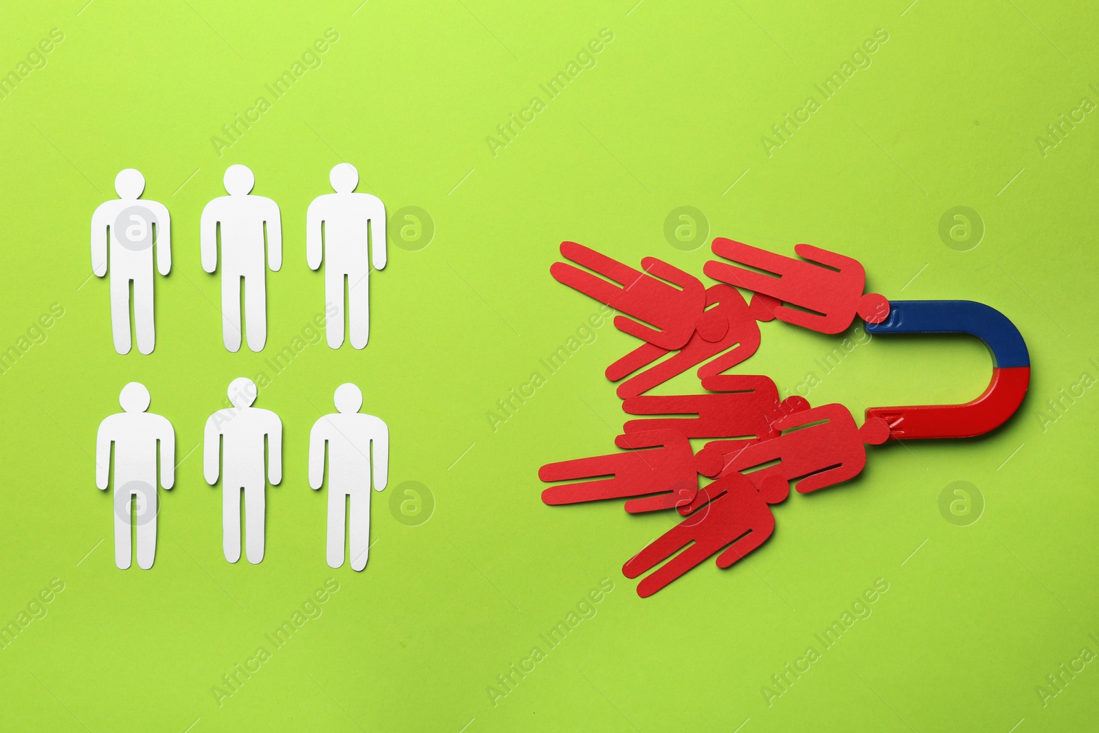 Photo of Magnet attracting paper people on color background, flat lay. Marketing concept