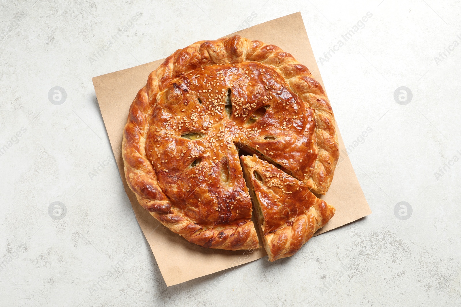 Photo of Cut delicious homemade pie on light grey table, top view