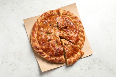 Photo of Cut delicious homemade pie on light grey table, top view