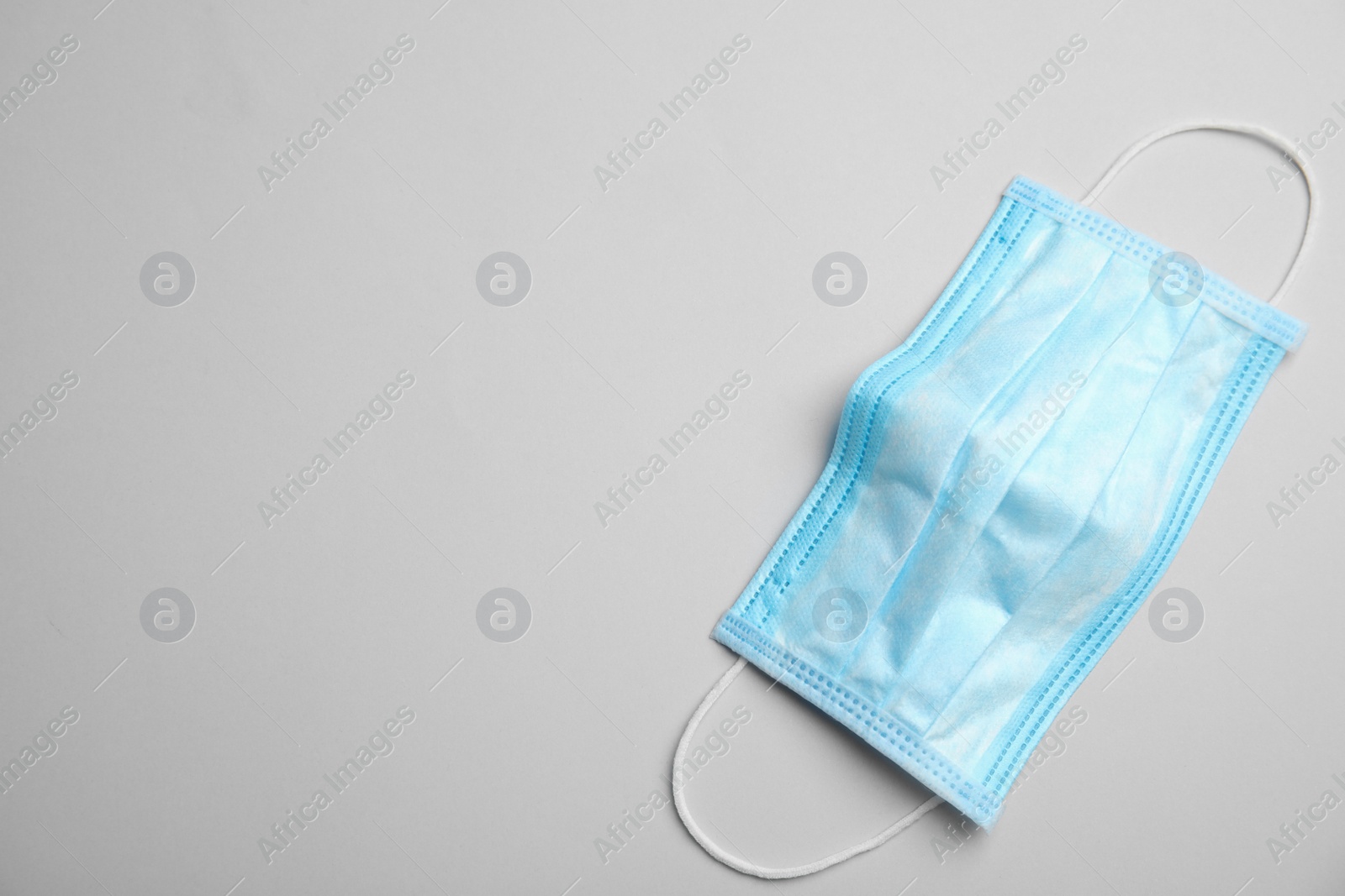 Photo of Medical face mask on grey background, top view. Space for text