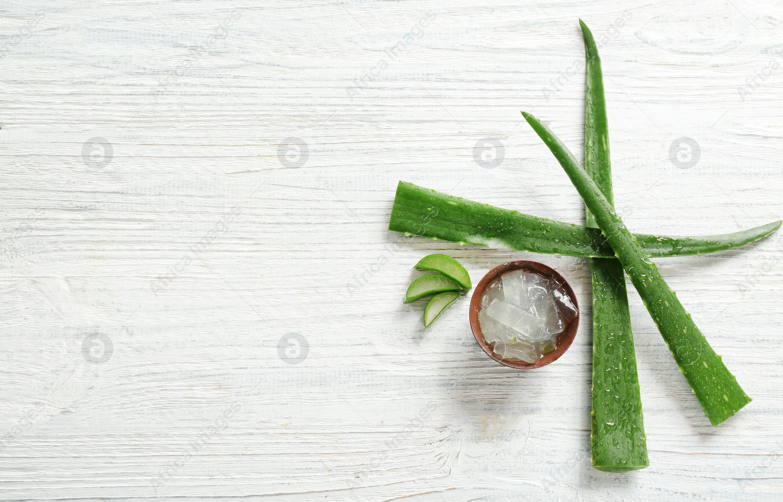 Photo of Flat lay composition with aloe vera leaves on wooden background. Space for text