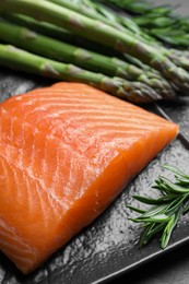 Photo of Fresh raw salmon and ingredients for marinade on black table, closeup