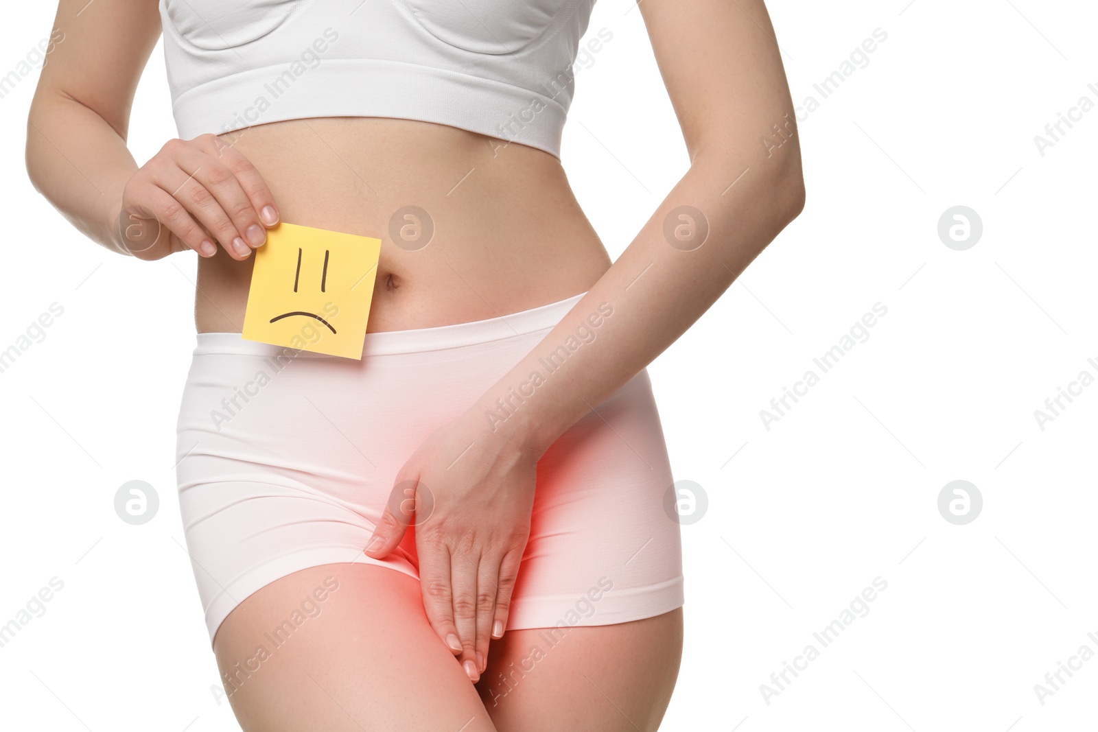 Image of Woman holding sticky note with drawn sad face and suffering from cystitis symptoms on white background, closeup
