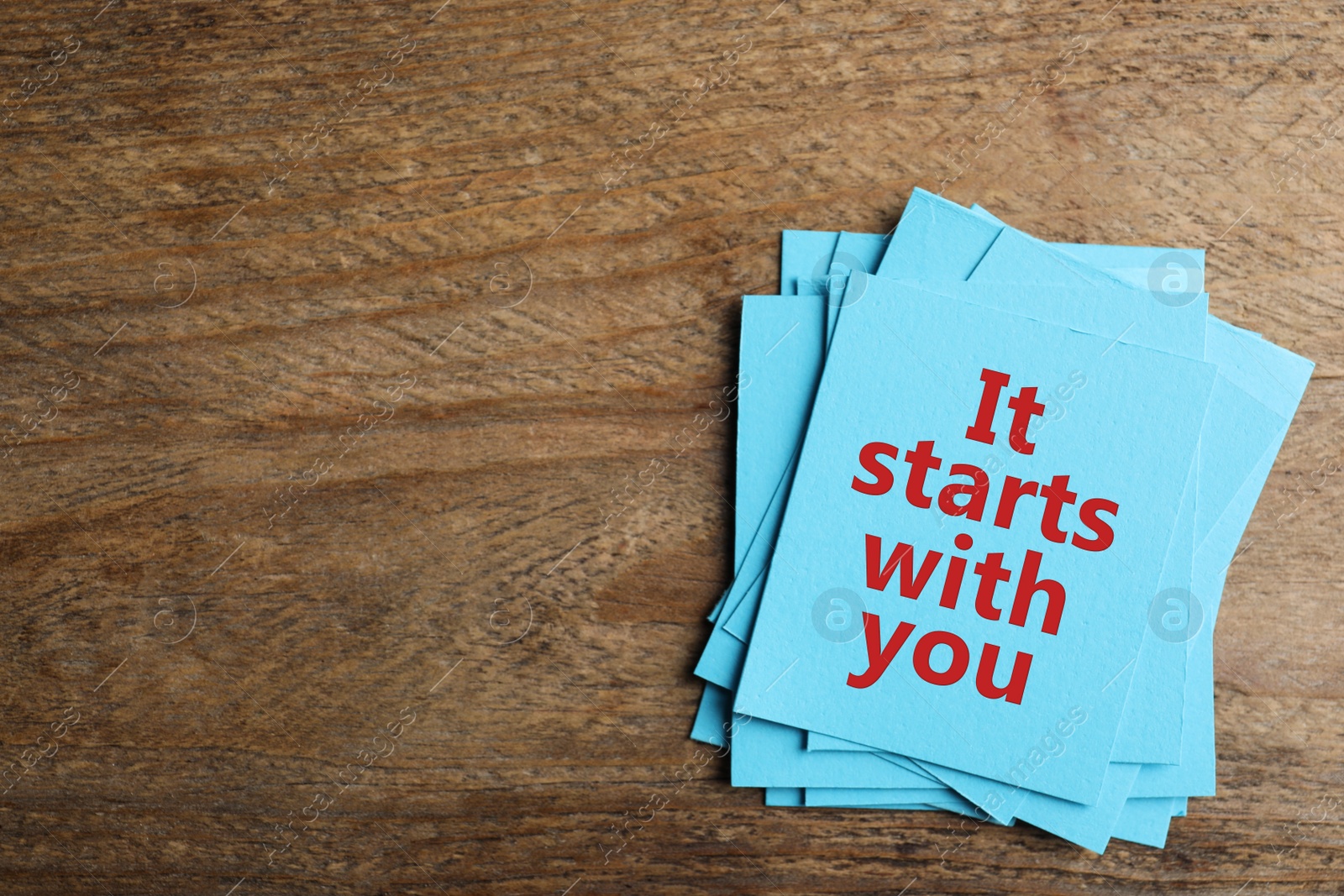 Image of Roles and responsibilities concept. Blue paper cards with phrase It stars with you and space for text on wooden table, top view