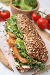 Photo of Delicious sandwich with schnitzel on white table, closeup