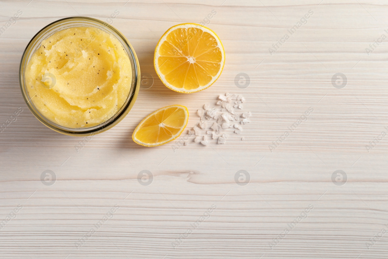 Photo of Body scrub in glass jar, sea salt on white wooden table, flat lay. Space for text