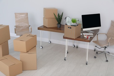 Interior of modern office with packed belongings. Moving service