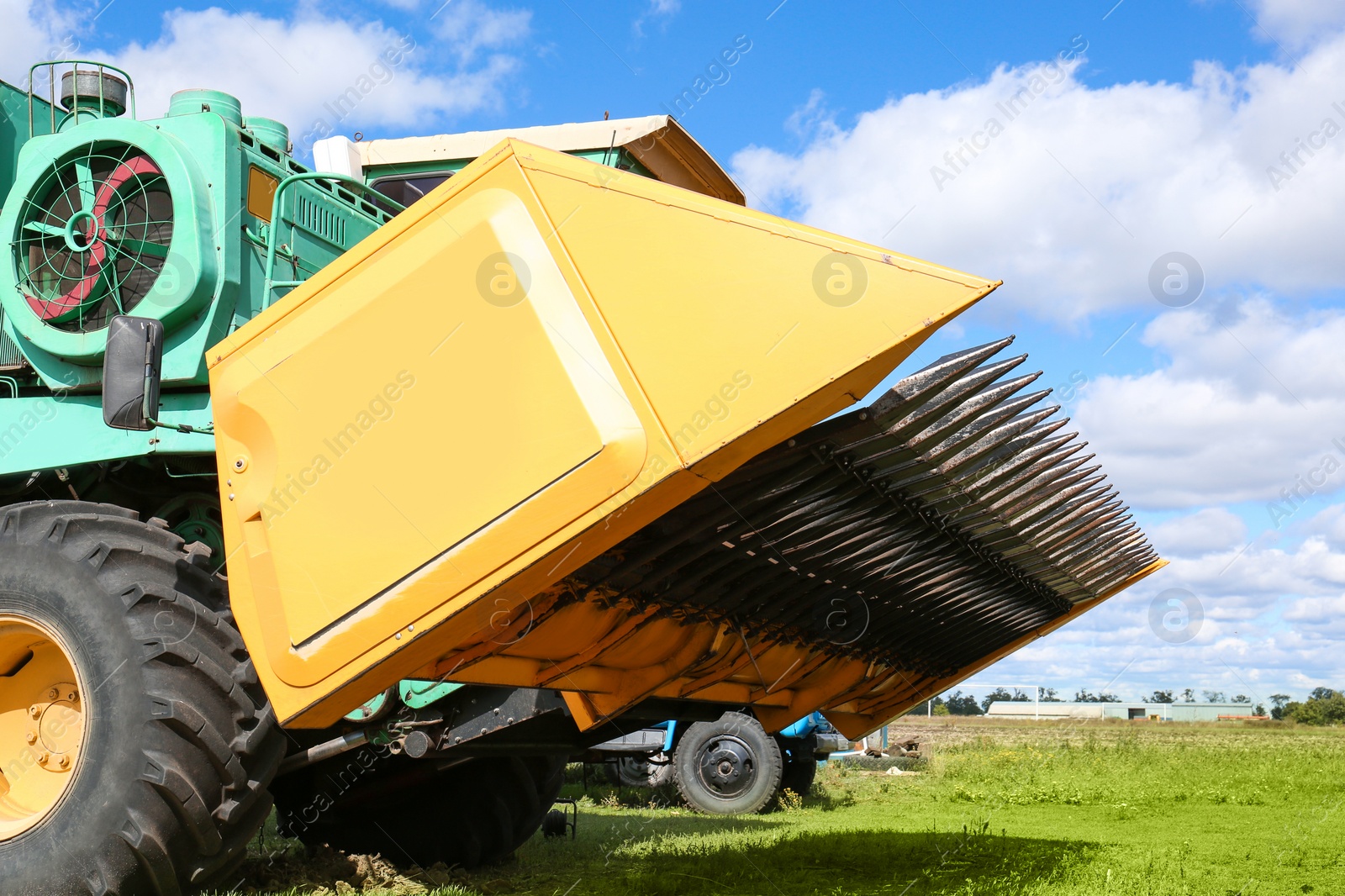 Photo of Modern combine harvester on green lawn with fresh grass