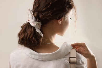Woman with stylish bandana on light background
