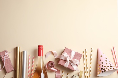 Photo of Creative flat lay composition with bottle of champagne and party accessories on color background. Space for text