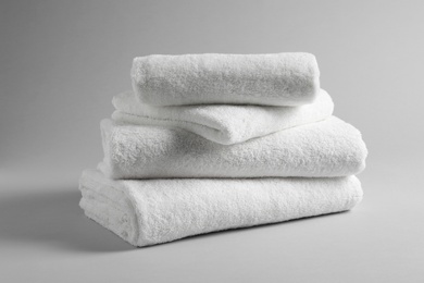 Stack of fresh towels on light background