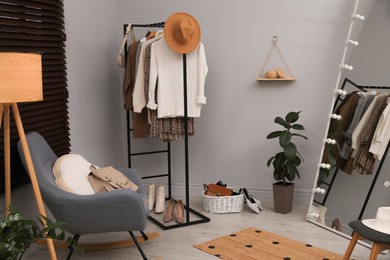 Photo of Modern dressing room interior with clothing rack and mirror