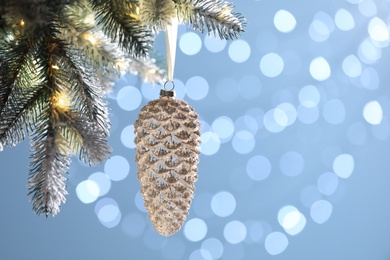 Photo of Christmas tree decorated with holiday bauble against blurred lights, closeup