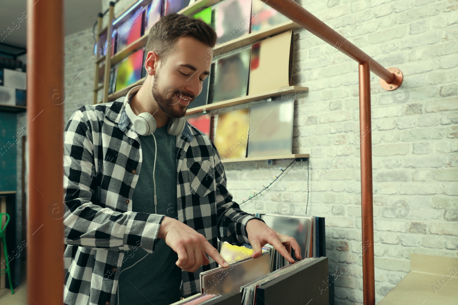 Image of Young man choosing vinyl records in store