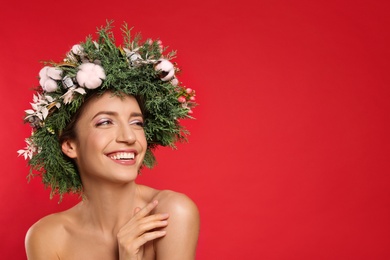 Photo of Happy young woman wearing wreath on red background. Space for text