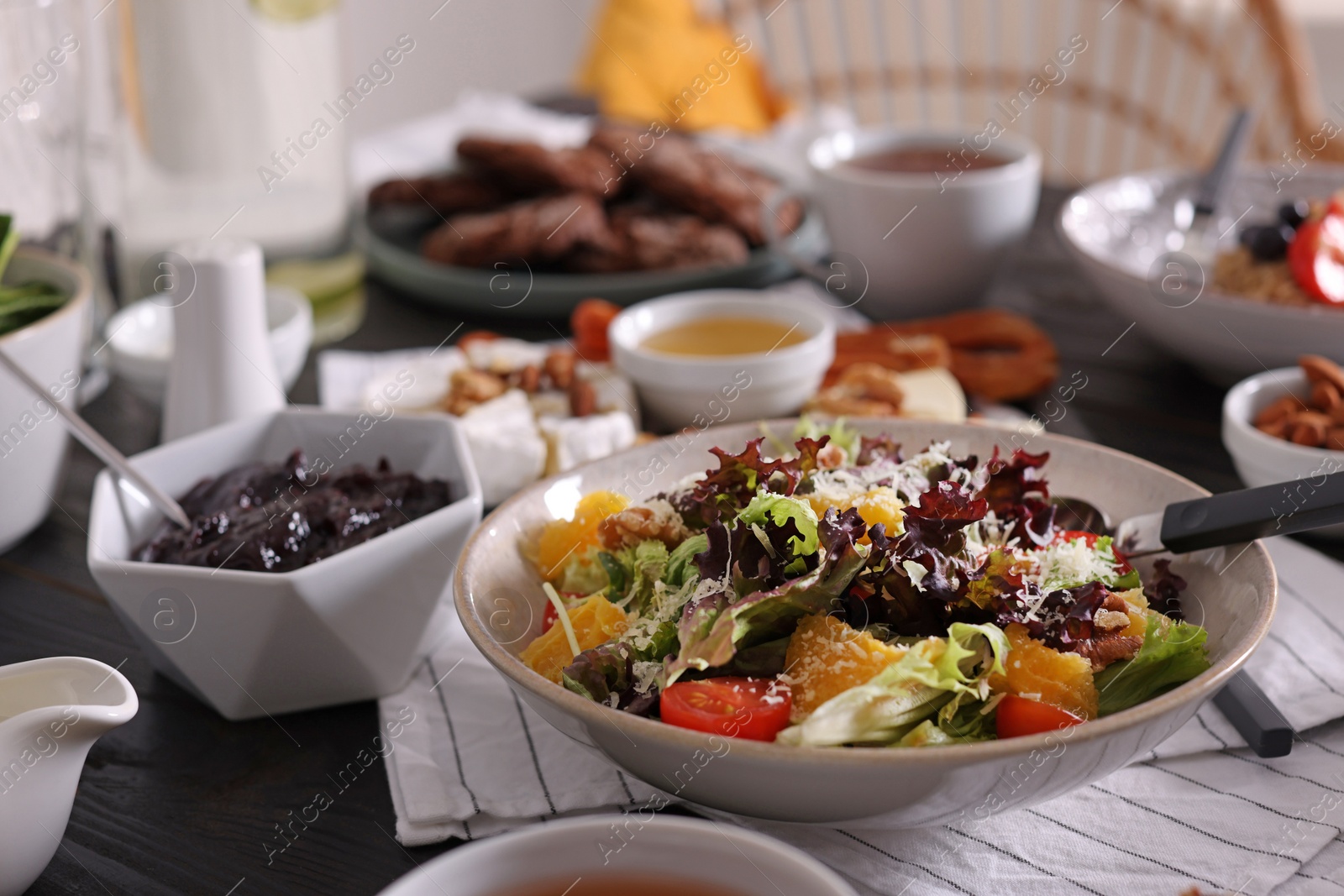 Photo of Delicious salad and many different dishes served on buffet table for brunch