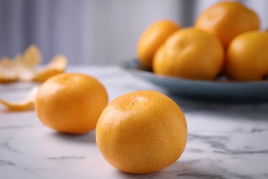 Photo of Delicious fresh tangerines on white marble table