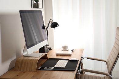 Photo of Stylish workplace interior with modern computer on table. Mockup for design