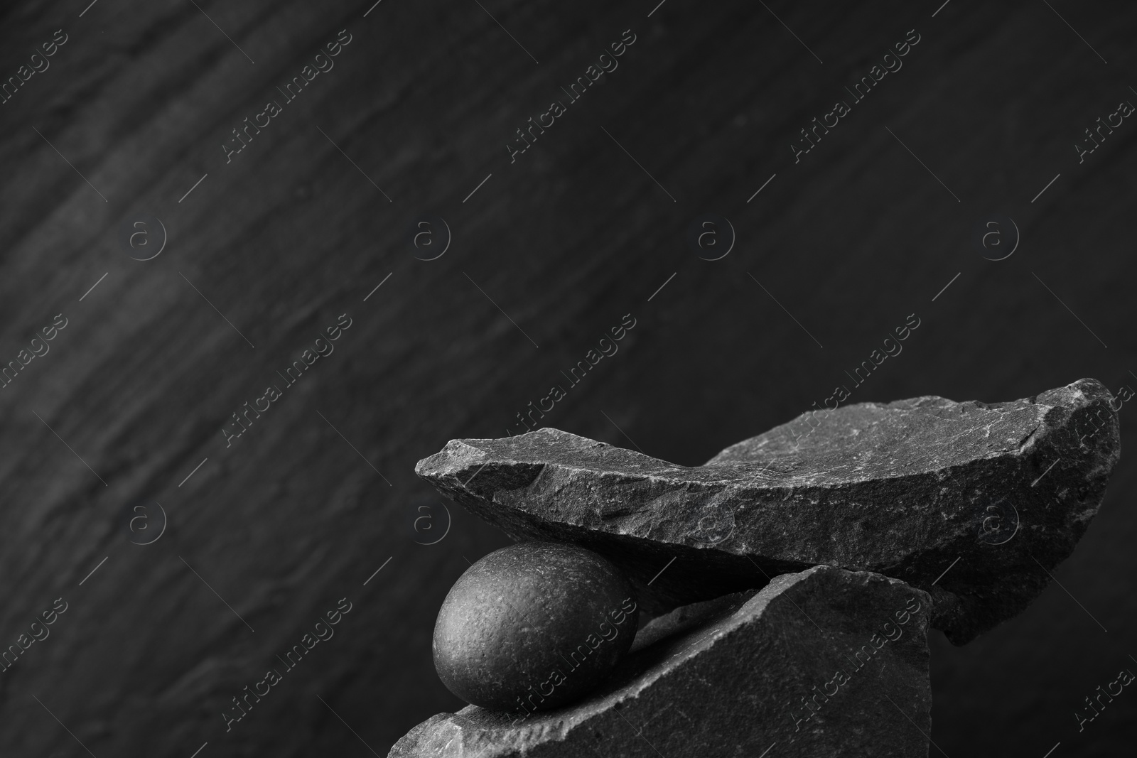 Photo of Presentation for product. Podium made of different stones on grey textured background. Space for text