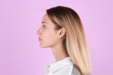 Young woman with hearing problem on color background