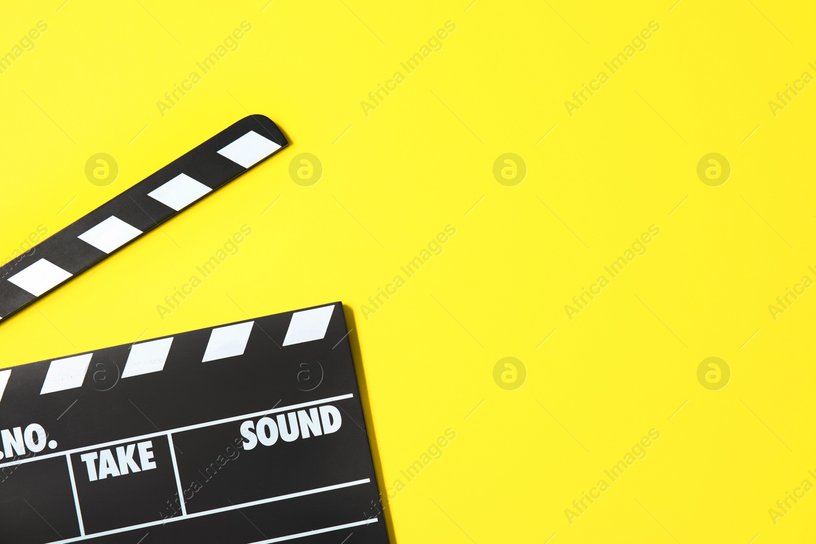 Photo of Clapperboard on color background, top view with space for text. Cinema production