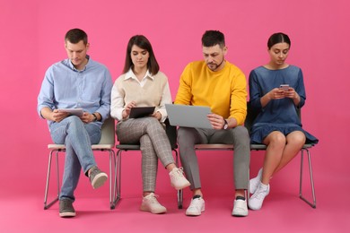 Photo of People waiting for job interview on pink background
