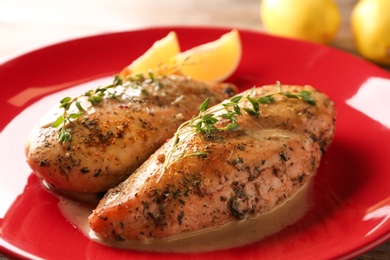 Photo of Baked lemon chicken with thyme served on plate, closeup