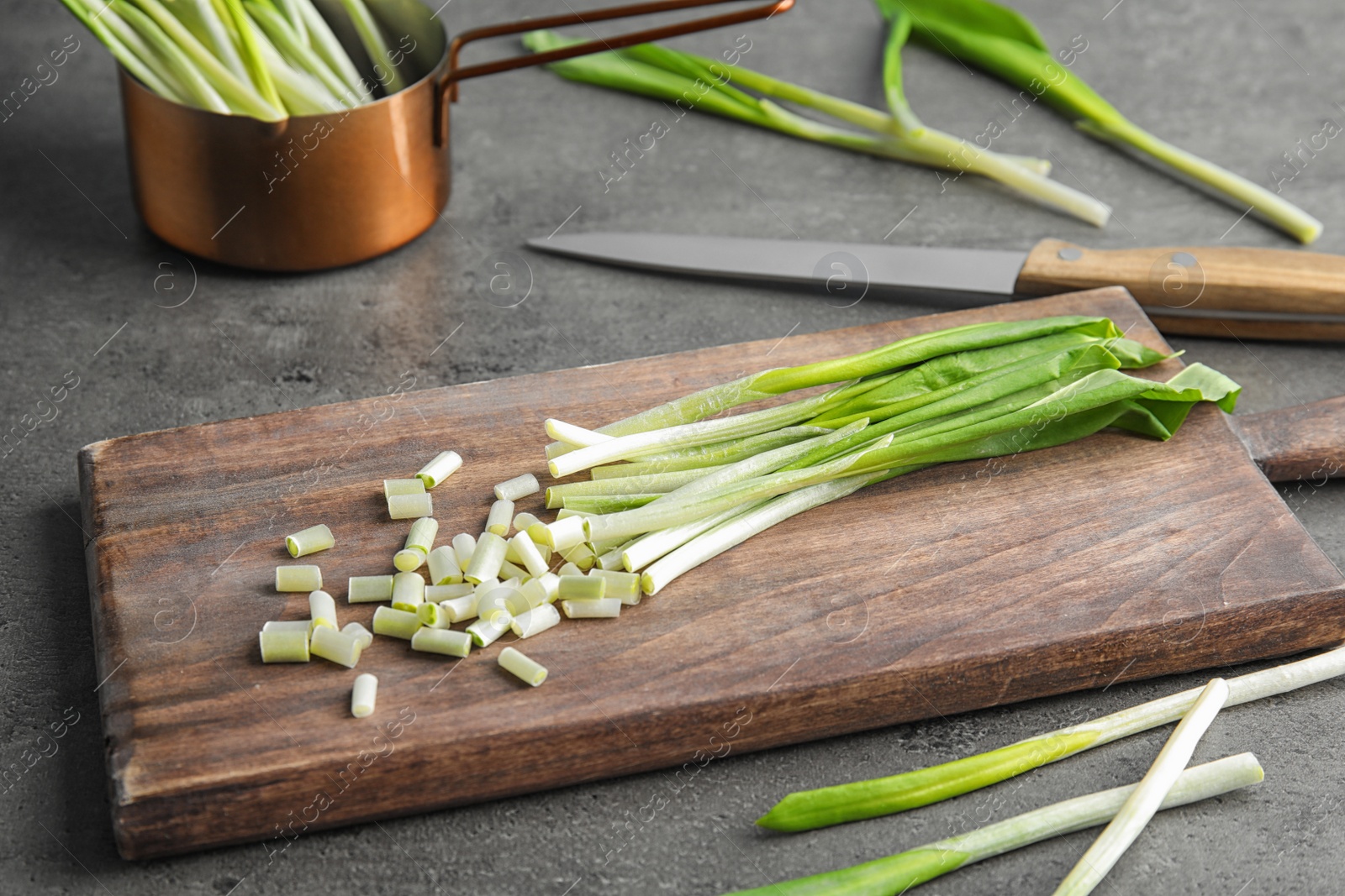 Photo of Board with wild garlic or ramson on grey table