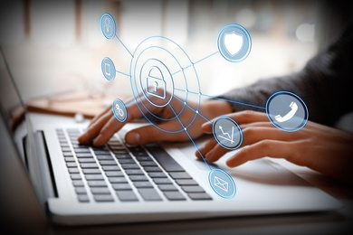 Image of Information security. Young woman using laptop at table indoors, closeup