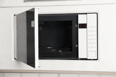 Open modern microwave oven built in kitchen furniture