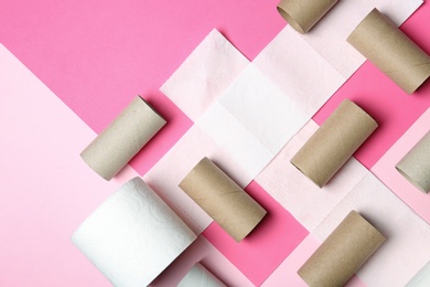 Flat lay composition with toilet paper and empty rolls on color background