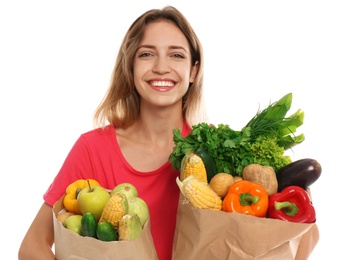 Young woman with bags of fresh vegetables isolated on white